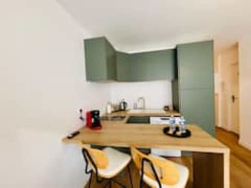 Cuisine moderne aux armoires vertes, table à manger en bois et chaises jaunes à l'appartement Les Logis d'Emma The Midori