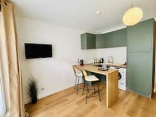 Kitchenette moderne avec coin bar dans l'appartement Midori des Logis d'Emma, avec bureau en bois et mobilier vert
