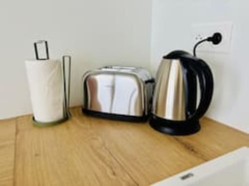 Appareils électroménagers sur plan de travail en bois : porte-essuie-tout, grille-pain et bouilloire électrique aux Logis d'Emma