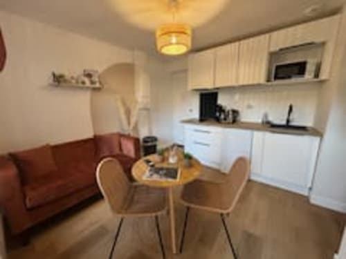 Cuisine et salle à manger modernes aux Logis d'Emma : mobilier blanc, table à dîner et canapé bordeaux