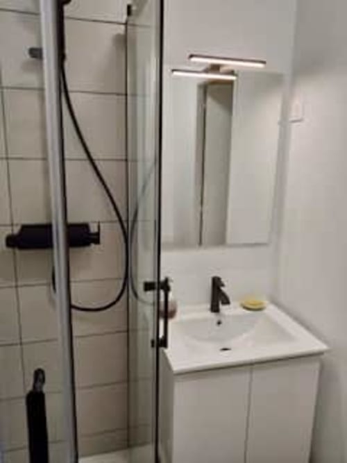 Salle de bain moderne de l'appartement Terravita aux Logis d'Emma avec vasque blanche et douche vitrée
