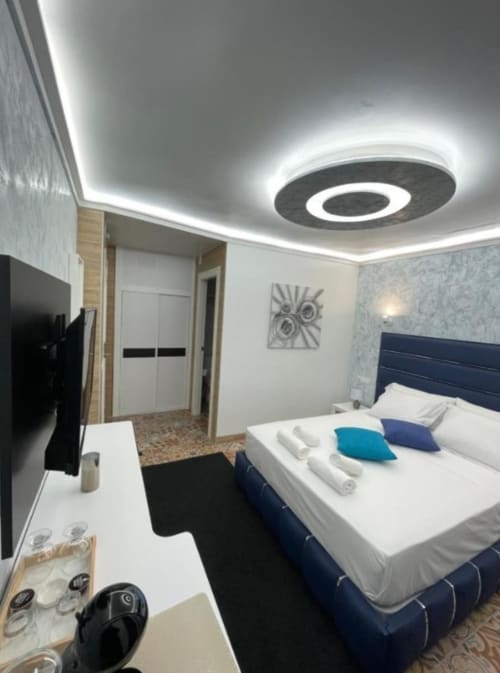 Habitación moderna del Hotel Boutique Galeon con cama doble, cabecero azul, iluminación LED en techo, TV y mobiliario contemporáneo