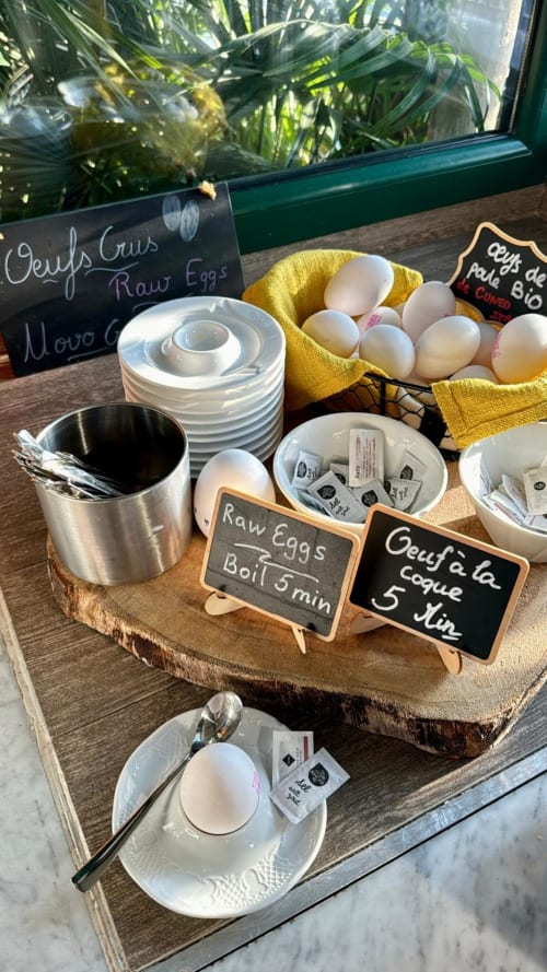 Présentation petit-déjeuner à l'Hôtel Reine D'Azur avec œufs frais en tissu jaune, équipement culinaire et tableaux pédagogiques