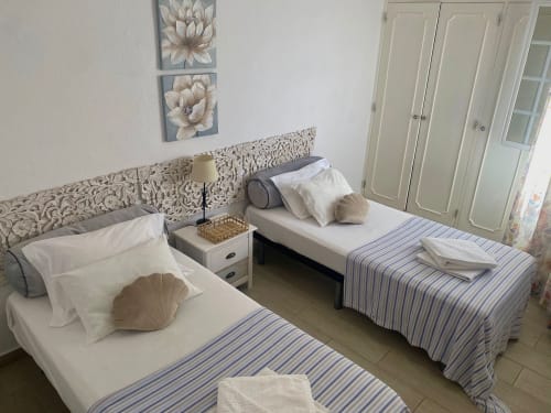 Duas camas de solteiro com colchas listradas azuis no brilhante Apartamento 2 do Hotel Al Mare Ocean View, Albufeira, com decoração