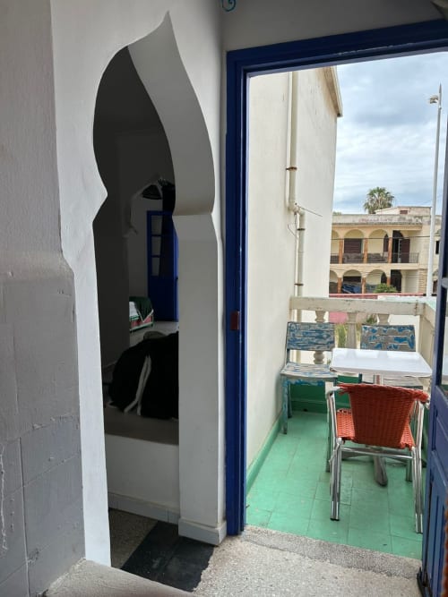 Namasté room at Yousurf Surfhouse hostel in Essaouira with balcony, coastal views, and outdoor seating area