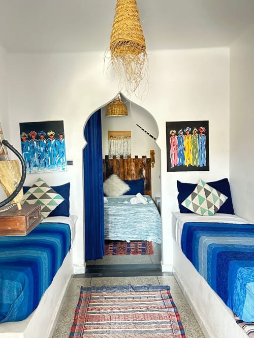 Berber hostel room at Yousurf Surfhouse in Essaouira with blue beds, woven lamp, and traditional artwork