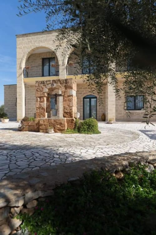 B&B Villa Arneide a Torre Lapillo con architettura moderna in pietra, balcone ad arco e edera