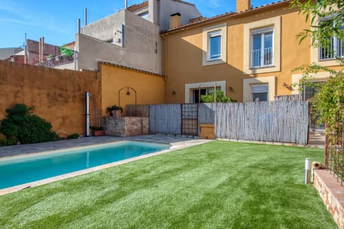 Casa amarillo ocre con piscina rectangular y jardín bien cuidado en Palafrugell, España
