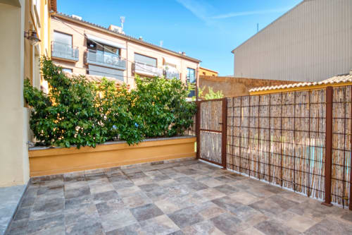 Terraza pavimentada con maceteros y valla de madera en Finques Garcia Enrich, Palafrugell