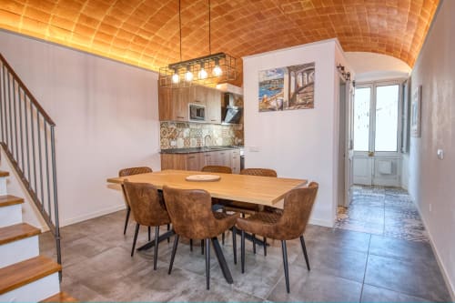 Comedor moderno en Finques Garcia Enrich en Palafrugell con mesa de madera, sillas marrones y cocina abierta