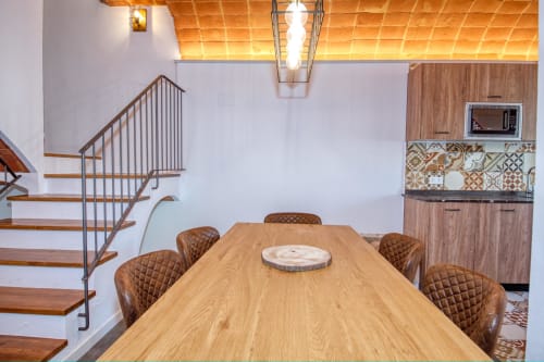 Comedor moderno con mesa de madera y sillas de cuero marrón en Finques Garcia Enrich en Palafrugell