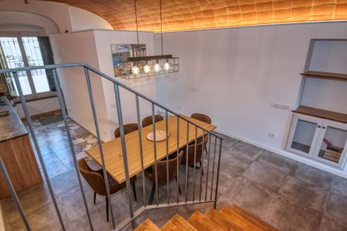 Zona de comedor tipo loft moderno en el hotel Finques Garcia Enrich de Palafrugell con mesa de madera, iluminación colgante contemporánea