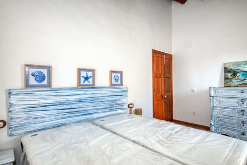 Dormitorio con temática costera en Finques Garcia Enrich, Palafrugell: cabecero a rayas azules, ropa de cama blanca y decoración náutica.