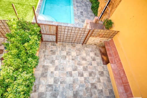 Vista aérea de la piscina y terraza de Finques Garcia Enrich en Palafrugell con piscina azul, patio de baldosas grises y exuberante vegetación