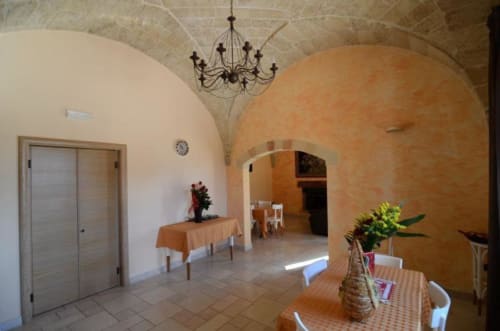 Camera tripla al B&B Villa Arneide di Torre Lapillo con soffitti a volta, lampadario e arredamento rustico mediterraneo