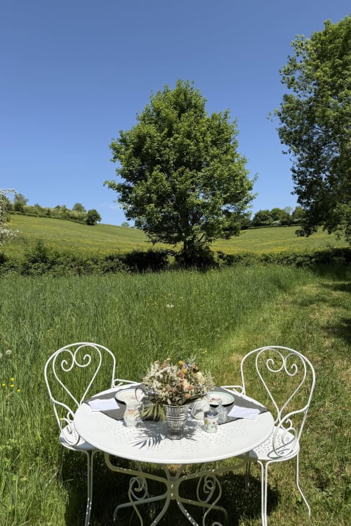 Romantic outdoor dining setup in green meadow at La Maison 1680, Couches France