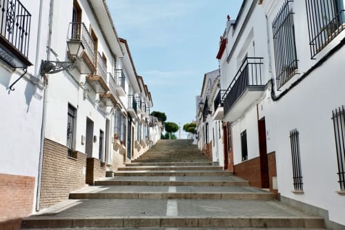 Rua de pedras encantadora com casarões caiados em Penamacor, Portugal, levando à pousada Moinho do Maneio