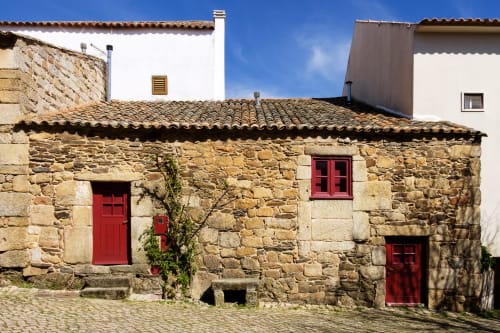 Historic stone cottage at Moinho do Maneio, Penamacor - rustic Portuguese guesthouse with red doors and traditional tile roof