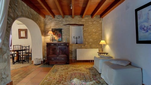 Els Llombos room at Casa Gallinera in Benissivà with rustic stone walls, wooden beams, and mountain views
