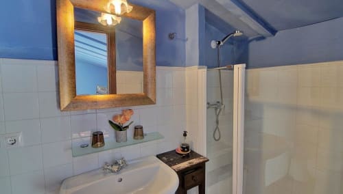Modern bathroom at Casa Gallinera vacation home in Benissivà with illuminated mirror, walk-in shower, and mountain view amenities