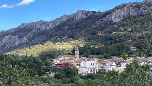 Benissivà village nestled in mountains with church tower, Casa Gallinera views from Tossal Gros room