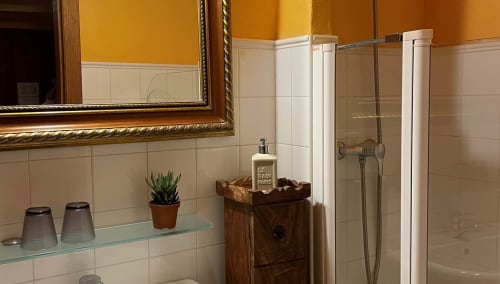 Bright bathroom at Casa Gallinera with yellow walls, white subway tiles, and mountain view from Tossal Gros room in Benissivà