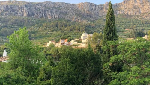 Casa Gallinera vacation home nestled in Benissivà valley with dramatic mountain cliffs and lush green landscape views