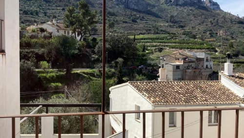 Balcony view from Tossal Gros room at Casa Gallinera, Benissivà, overlooking terracotta roofs and mountain landscape