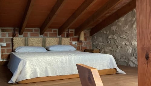 L'Umbria bedroom at Casa Gallinera in Benissivà with wooden beams, brick walls, and mountain views