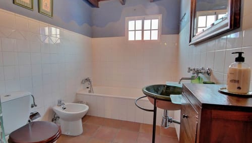 Spacious bathroom in L'Umbria room at Casa Gallinera, Benissivà with bathtub, bidet, wooden vanity and white tile walls
