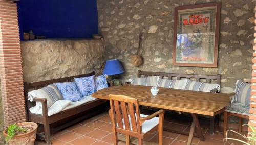 Rustic terrace seating area at Casa Gallinera in Benissivà with wooden table and bench seat