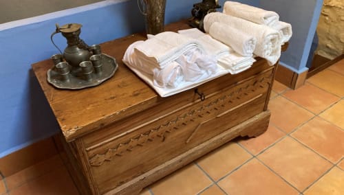Wooden dresser with rolled towels and antique brass pitcher at Casa Gallinera