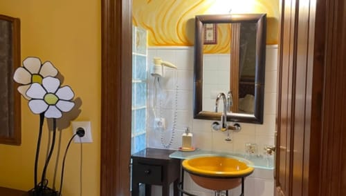 La Solana bathroom at Casa Gallinera in Benissivà with yellow sink, floral wall art, and modern fixtures