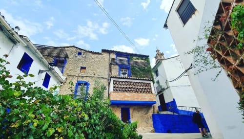 Casa Gallinera in Benissivà featuring blue-trimmed stone architecture with ivy and climbing plants