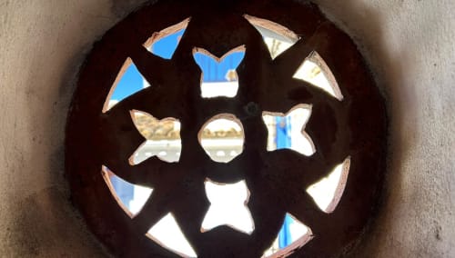 Decorative circular mirror with mirrored cutout shapes at Casa Gallinera in Benissivà