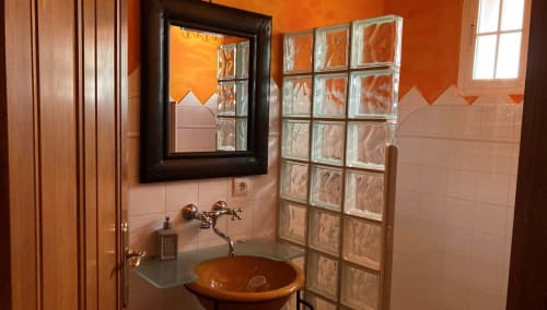 Modern bathroom at Casa Gallinera in Benissivà with round terracotta sink, glass block window, and orange accent walls