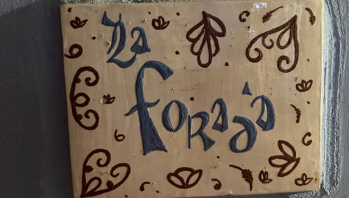 Decorative tile at Casa Gallinera Benissivà featuring 'La Foradà' room name with ornamental floral design