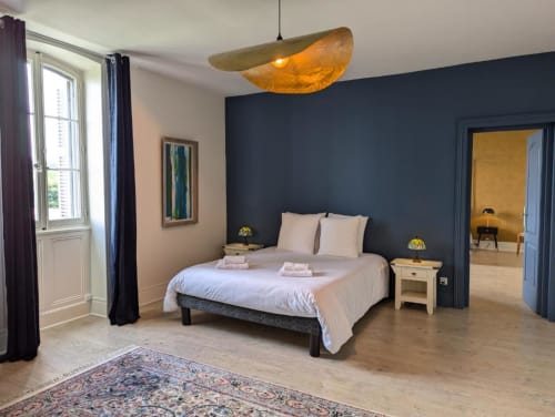 Chambre Suite Le Faure du Domaine du Faure à Chadurie avec lit queen-size, mur d'accent bleu foncé et luminaire suspendu