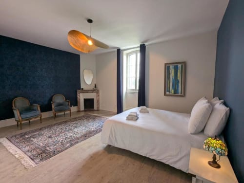 Suite Le Faure au Domaine du Faure avec lit queen, coin salon, cheminée et vue sur le jardin