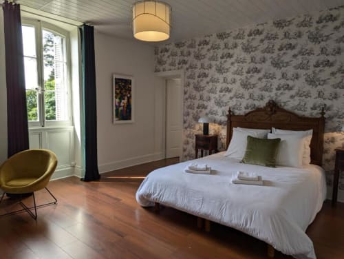 Suite élégante au Domaine du Faure avec parquet, vue sur le jardin et papier peint raffiné