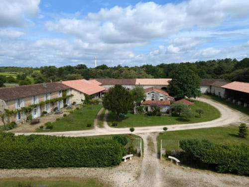 Vue aérienne du Domaine du Faure, charmant gîte français à Chadurie avec bâtiments aux toits de terre cuite, jardins soignés