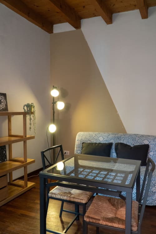 Moderno loft con soffitto spiovente, lampada da terra, scaffali in legno e letto con motivi decorativi