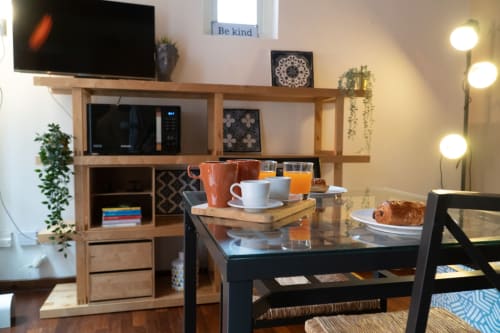 Angolo cottura Naviglio Grande con scaffali in legno, microonde, tavolo da pranzo e colazioni in appartamento a Torino