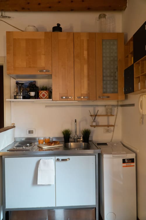 Cucina compatta nella Naviglio Grande Suite dell'hotel A-waay di Torino, con mobili in legno e lavello in acciaio inox