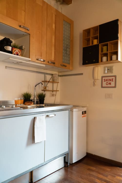 Cucina moderna della Naviglio Grande Suite presso l'hotel A-waay Torino, con mobili in legno e elettrodomestici compatti
