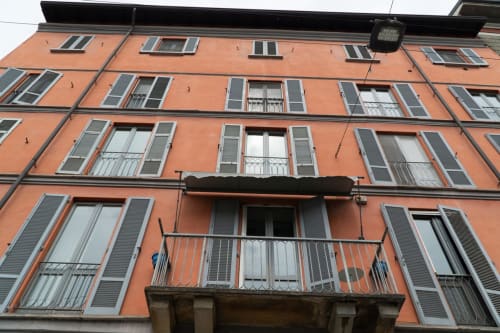 Storico edificio residenziale arancione a Torino con finestre e balconate scuri, esterno della Naviglio Grande Suite