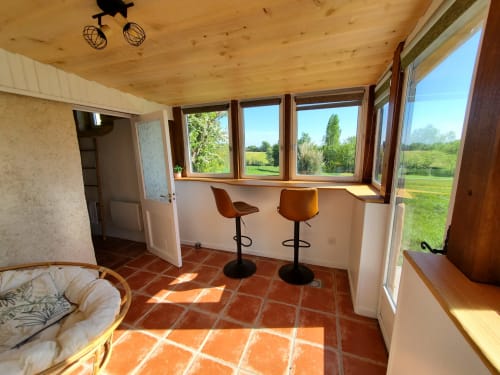 Chambre lumineuse au Clos Des Sources avec bar, carrelage en terre cuite, plafond en bois et vue panoramique sur le jardin