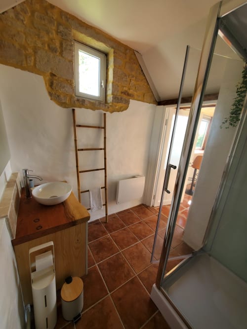 Salle de bain moderne du gîte La Boulangerie au Clos Des Sources, Isigny-sur-Mer, avec murs en pierre apparente et bois