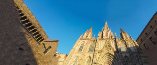Catedral Gótica de Barcelona con agujas doradas bajo cielo azul, cerca del hotel Apartamenting SL