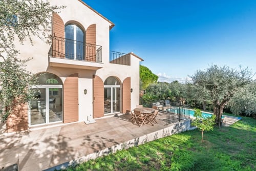 Private villa in Cannes Mougin with terrace, pool view, and Mediterranean architecture featuring arched windows and olive